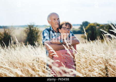 Man de câlins avec sa femme dans l'herbe Banque D'Images