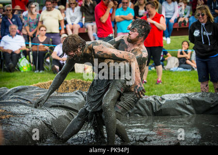 Deux hommes de la boue lutte lors d'un combat de boue à la concurrence dans les jeux de plaine Thorney Somerset Banque D'Images