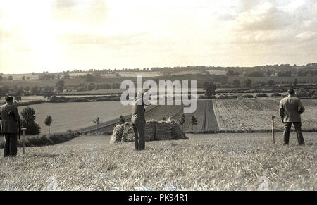 Années 1930, historiques, pays rural, messieurs dans une tenue appropriée prenant part à un tournage sur une colline, à une campagne traditionnelle britannique. fieldsport Banque D'Images