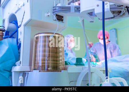 Fragment d'un appareil respiratoire autonome dans la salle d'opération, l'arrière-plan flou avec le chirurgien de l'équipe au travail à l'hôpital pendant leur travail. Banque D'Images