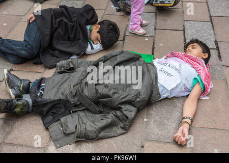 Glasgow, Scotland, UK - 17 juin 2012 : Les Syriens protester contre Bachar al-Assad crimes de guerre près de Donald Dewar statue. Les enfants à plat sur marbre faisant semblant d'être de Banque D'Images