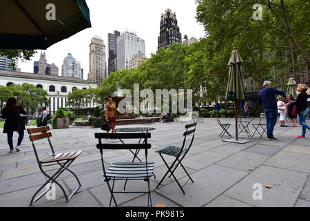 Chaises vides à Bryant Park, à Manhattan, New York City, New York, USA ; avec des gratte-ciel en arrière-plan. Banque D'Images