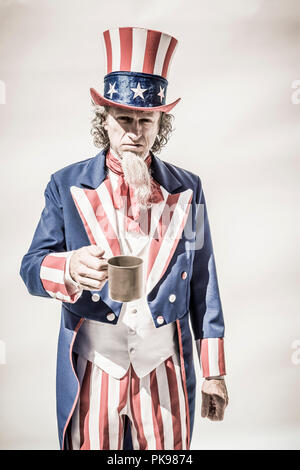 Caractère de l'Oncle Sam apparaissant être mendier avec une tasse. Banque D'Images