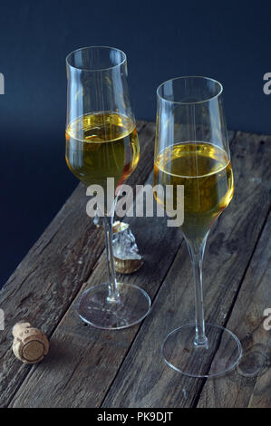 Deux verres de vin mousseux avec bouteille sur avion en bois Banque D'Images