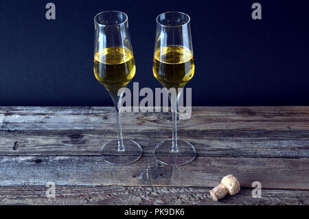 Deux verres de vin mousseux avec bouteille sur avion en bois Banque D'Images