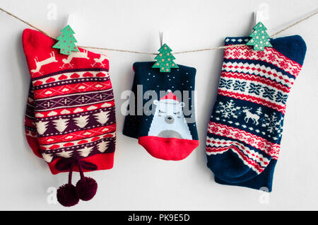 Chaussettes de noël pour toute la famille suspendu à la corde à linge sur fond blanc. Concept des vacances d'hiver. Banque D'Images