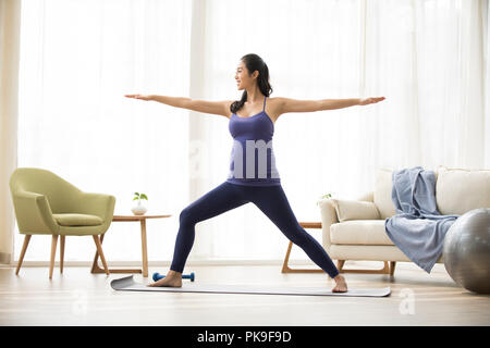 Cheerful pregnant woman practicing yoga at home Banque D'Images