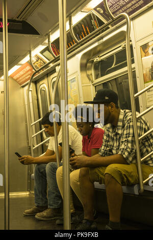 Constamment des gens utiliser leur téléphone alors qu'ils montent le New York CIty Subway. Banque D'Images