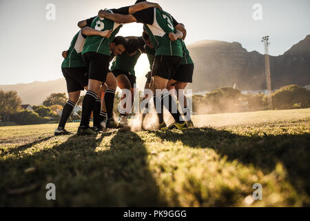joueurs de rugby en caucus frottant les pieds sur l'herbe. équipe de rugby montrant l'agressivité après la victoire. Banque D'Images