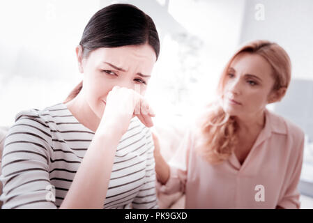 Femme triste à pleurer tout en visitant son psychanalyste expérimenté Banque D'Images