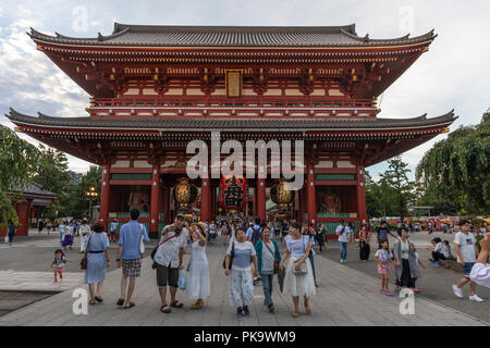 Les visiteurs du temple Senso-ji à Tokyo poser pour des photos en face de la porte du temple Hozomon Banque D'Images