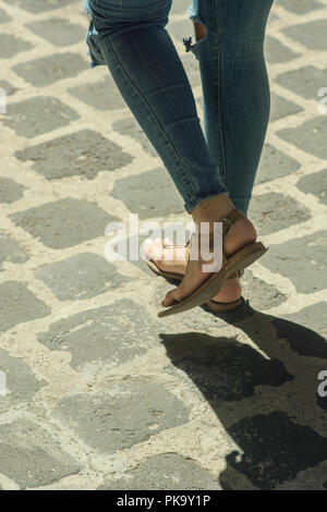 Close up of a woman's pieds marchant sur une route pavée Banque D'Images