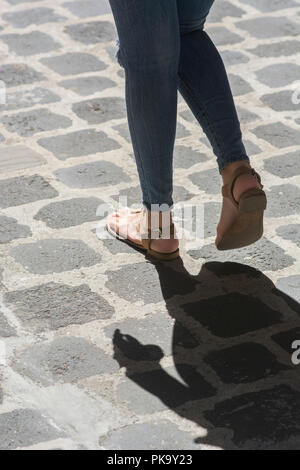 Close up of a woman's pieds marchant sur une route pavée Banque D'Images