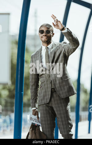Young african american businessman waving à quelqu'un sur gare Banque D'Images