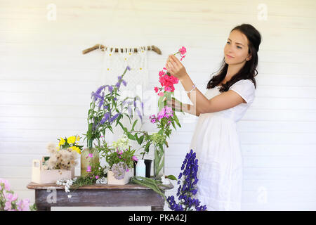 La jeune fille décore un bouquet de fleurs séchées Banque D'Images