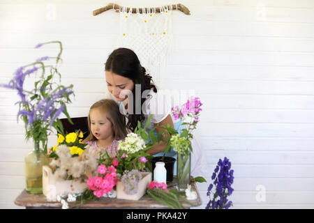 La jeune fille décore un bouquet de fleurs séchées Banque D'Images