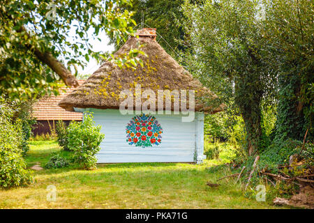 Zalipie, Pologne, le 19 août 2018 : maison colorée avec des fleurs peintes sur les murs et le cadran solaire dans le village de Zalipie, Pologne. Il est connu pour un loca Banque D'Images