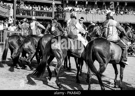 Jockeys dressed in costumes qui représentent leur Contradas se préparent à prendre part à l'un des six courses d'essai qui précèdent le Palio, Sienne, Italie Banque D'Images