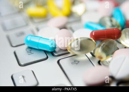 Pile de médecine assortis pills and capsules sur clavier gris, macro fond pharmaceutique. Banque D'Images