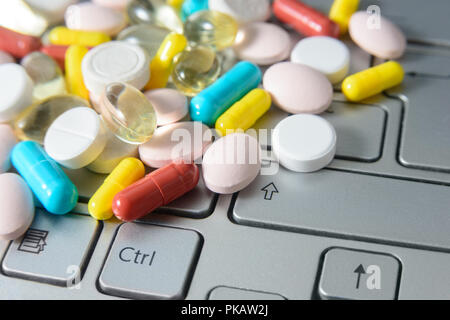 Pile de médecine assortis pills and capsules sur clavier gris, macro fond pharmaceutique. Banque D'Images