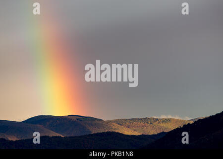 Belle et surréaliste vue d'une partie d'un arc-en-ciel sur certaines collines Banque D'Images