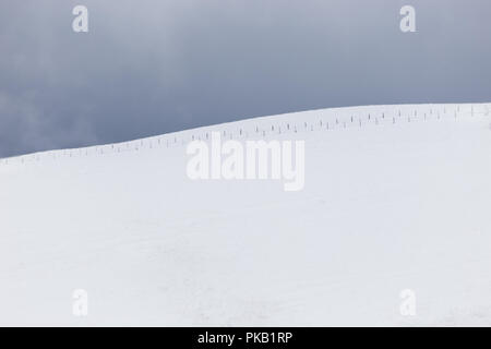 Une vue d'un minimaliste très montagne couverte par la neige, avec une clôture Banque D'Images