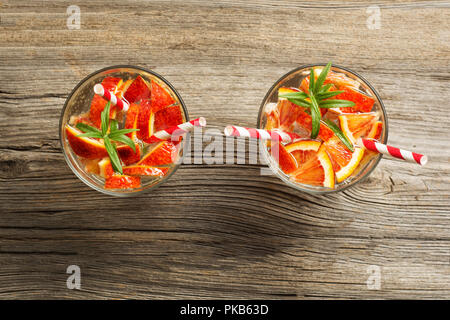 Deux verres de boisson rafraîchissante à l'orange et le romarin sur le vieux fond de bois . Concept de recette, cocktail. Vue d'en haut. Banque D'Images