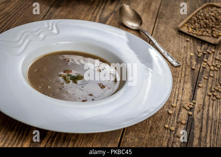 Lentilles brunes avec saucisse sop sur table en bois Banque D'Images