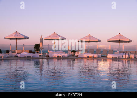 Coucher de soleil Pastel Lumière sur piscine et bains de soleil Banque D'Images