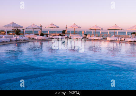 Coucher de soleil Pastel Lumière sur piscine et bains de soleil Banque D'Images