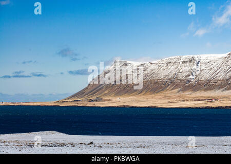 Nuage de neige et de montagnes enneigées à proximité de la mer, à l'Islande, de Hvalfjörður Banque D'Images