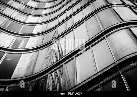 Bâtiment incurvé avec windows brillant avec reflets dans ton noir et blanc Banque D'Images