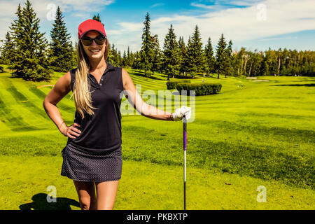 Portrait d'un golfeur féminin debout avec son pilote sur l'herbe verte d'un club de golf ; Edmonton, Alberta, Canada Banque D'Images