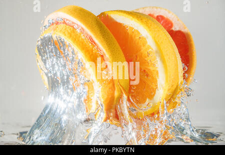 Le pamplemousse et l'orange qui sort de l'eau. Convient pour la publicité. Banque D'Images