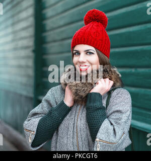 Fille élégante en hiver vêtements en tricot vintage sur fond d'une vieille maison en bois vert Banque D'Images