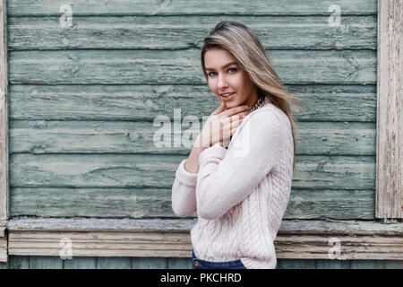 Belle jeune fille sur le fond d'un vieux mur de bois avec une éraflée Banque D'Images