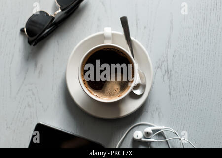 Café sur la table en bois avec le téléphone avec un casque et lunettes Banque D'Images