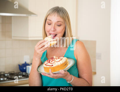 Femme mangeant un gâteau à la crème Banque D'Images