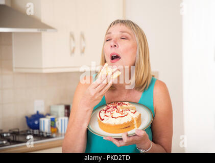 Femme mangeant un gâteau à la crème Banque D'Images