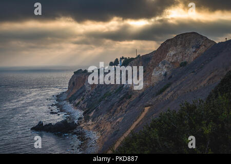 Superbe vue sur la côte de coucher du soleil à l'abrupte falaise de Pelican Cove Park sur un jour nuageux avec des faisceaux de lumière du soleil piquer à travers les nuages au-dessus de Point V Banque D'Images