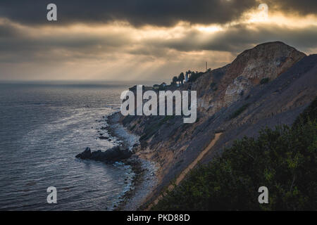 Superbe vue sur la côte de coucher du soleil à l'abrupte falaise de Pelican Cove Park sur un jour nuageux avec des faisceaux de lumière du soleil piquer à travers les nuages au-dessus de Point V Banque D'Images