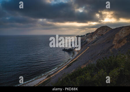 Superbe vue sur la côte de coucher du soleil à l'abrupte falaise de Pelican Cove Park sur un jour nuageux avec des faisceaux de lumière du soleil piquer à travers les nuages au-dessus de Point V Banque D'Images