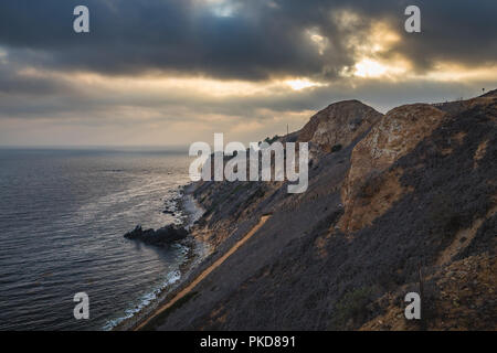 Superbe vue sur la côte de coucher du soleil à l'abrupte falaise de Pelican Cove Park sur un jour nuageux avec des faisceaux de lumière du soleil piquer à travers les nuages au-dessus de Point V Banque D'Images