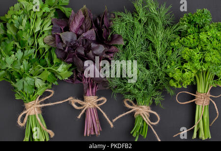 Mélange de bouquets d'herbes épicées attachés avec une corde sur un plan macro tableau noir Banque D'Images