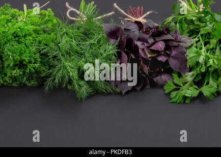 Mélange de bouquets d'herbes épicées attachés avec une corde sur un plan macro tableau noir Banque D'Images