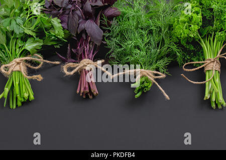 Mélange de bouquets d'herbes épicées attachés avec une corde sur un plan macro tableau noir Banque D'Images