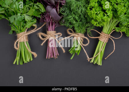 Mélange de bouquets d'herbes épicées attachés avec une corde sur un plan macro tableau noir Banque D'Images