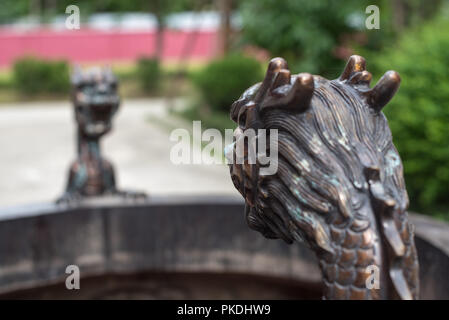 Selective focus sur une tête de dragon sur un brûleur d'encens en bronze dans un temple chinois Banque D'Images
