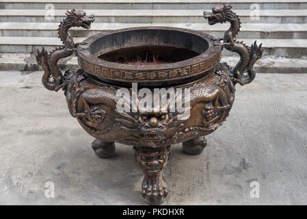 Brûleur d'encens en bronze dans un temple chinois avec décorations dragon Banque D'Images