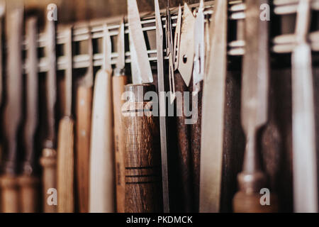 Gros plans extrêmes de la pendaison à l'intérieur des outils de menuiserie. La vie menuiserie acier, lames, accessoires de forage, poignées en bois, et des poignées. Florence, Italie Banque D'Images